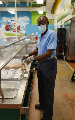 Volunteer preparing food in a cafeteria